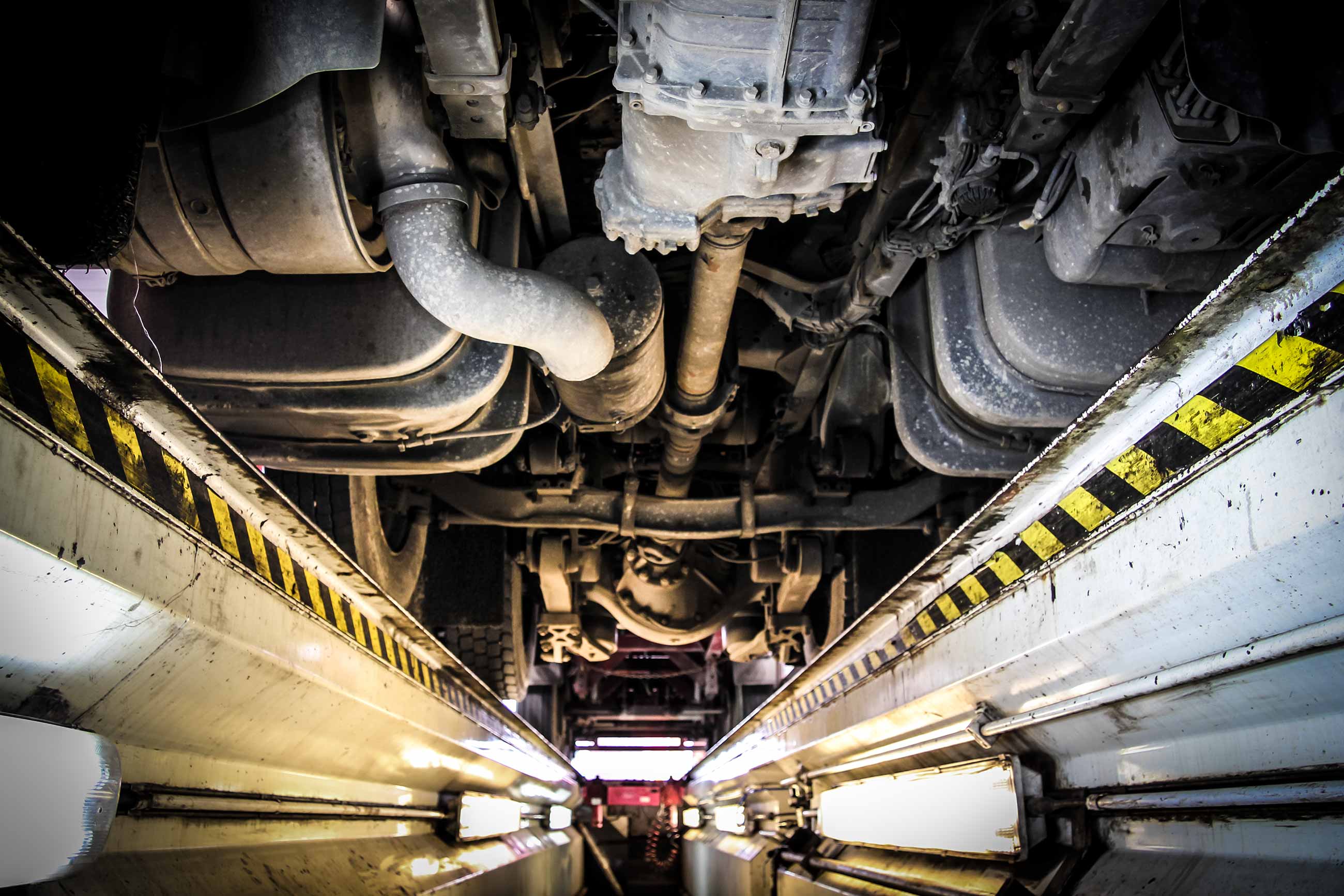 Inspecting the underside of a truck from a test lane pit